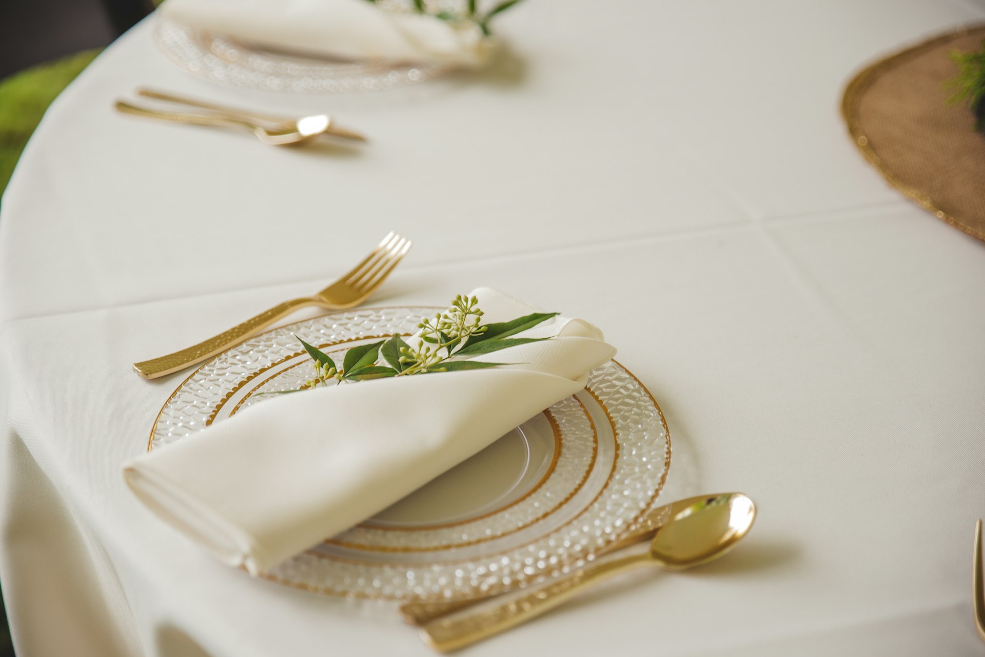 Elegant place setting with gold cutlery and a linen napkin