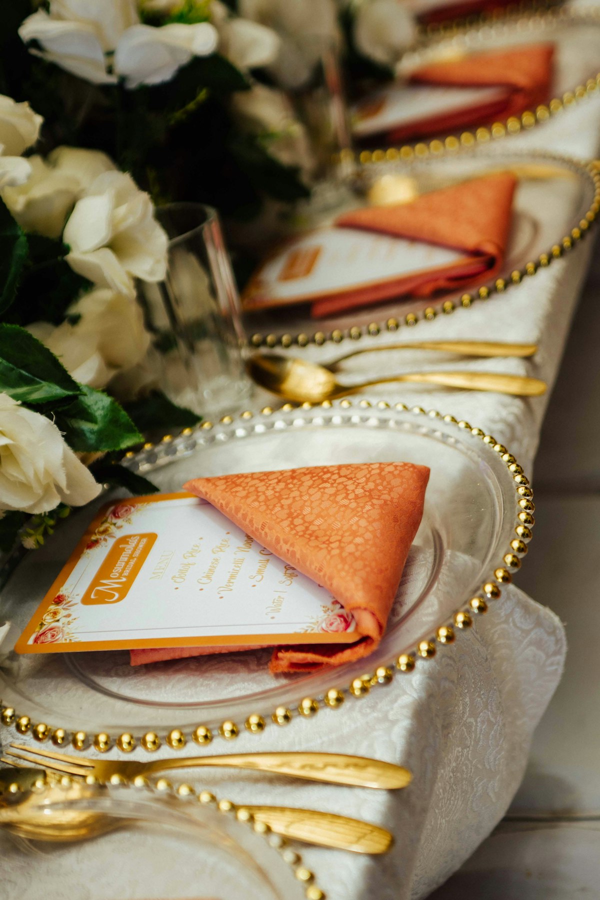 Orange napkin on a gold beaded charger