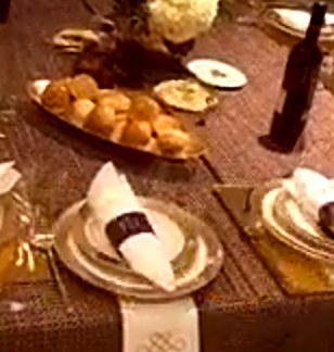 Gold napkin rings on a woven runner